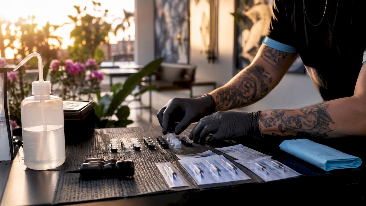 Gloved hands organizing ink cups and needles