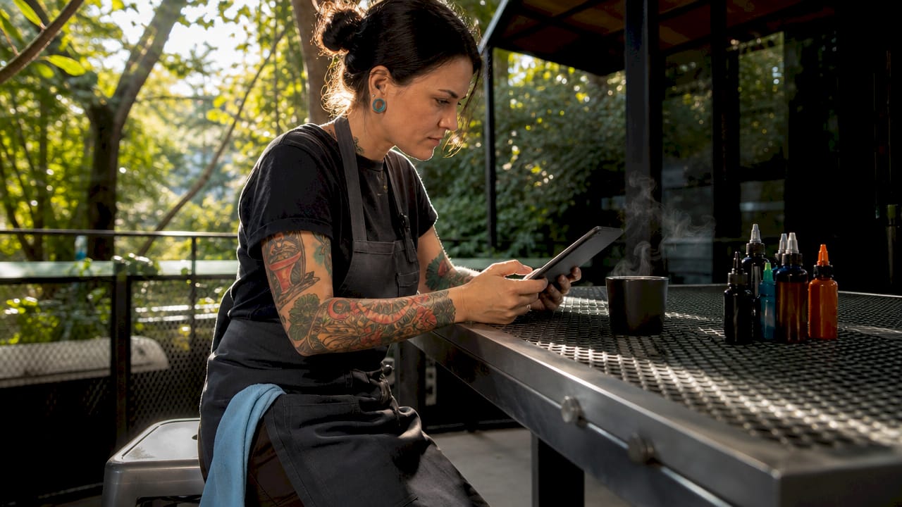 Tattoo artist confirming appointments on laptop