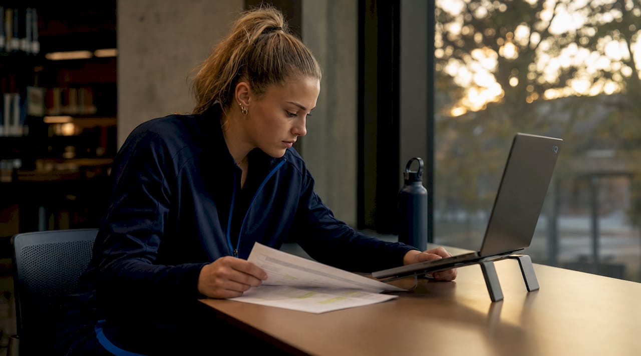 Female athlete checking academic support plan in dorm