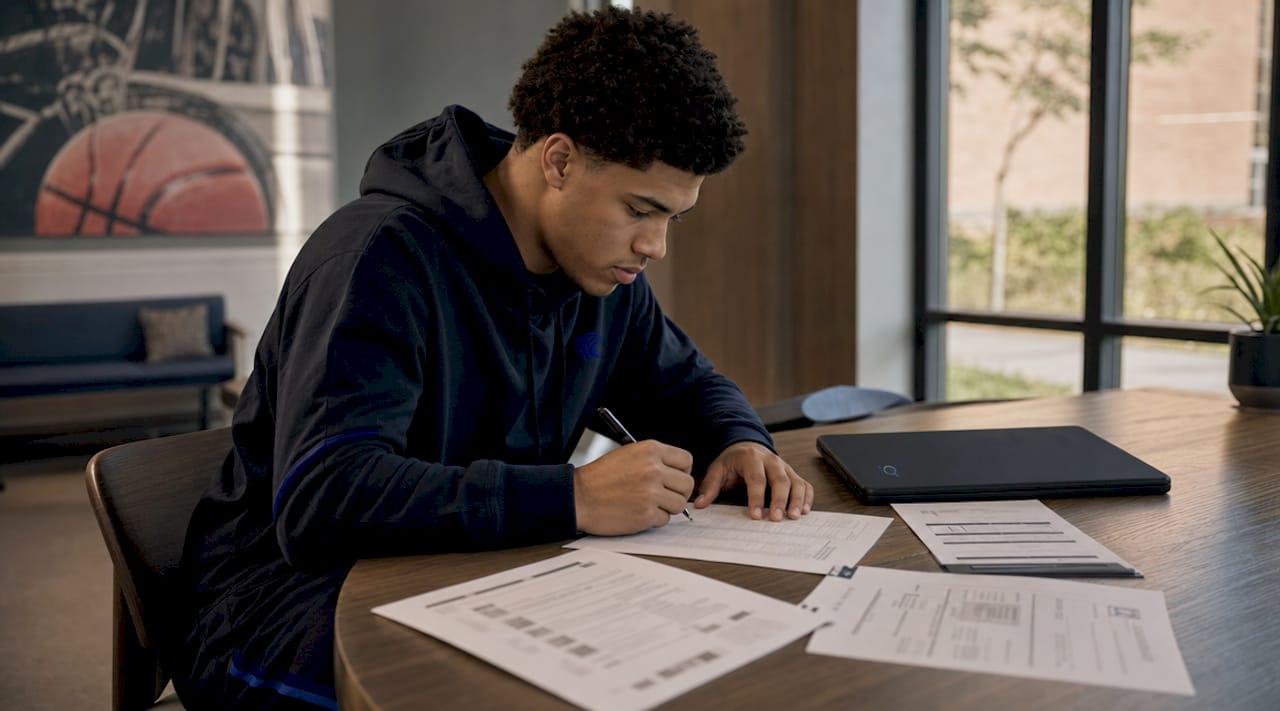 College athlete reviewing transfer checklist at desk