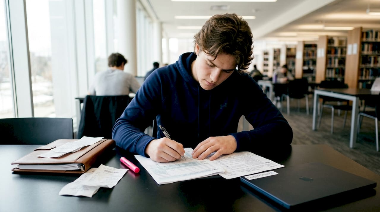 Hands filling tax forms with pen close-up