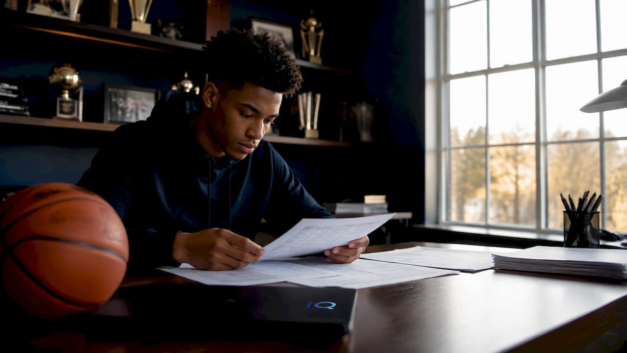 Teen athlete studying team roster sheets