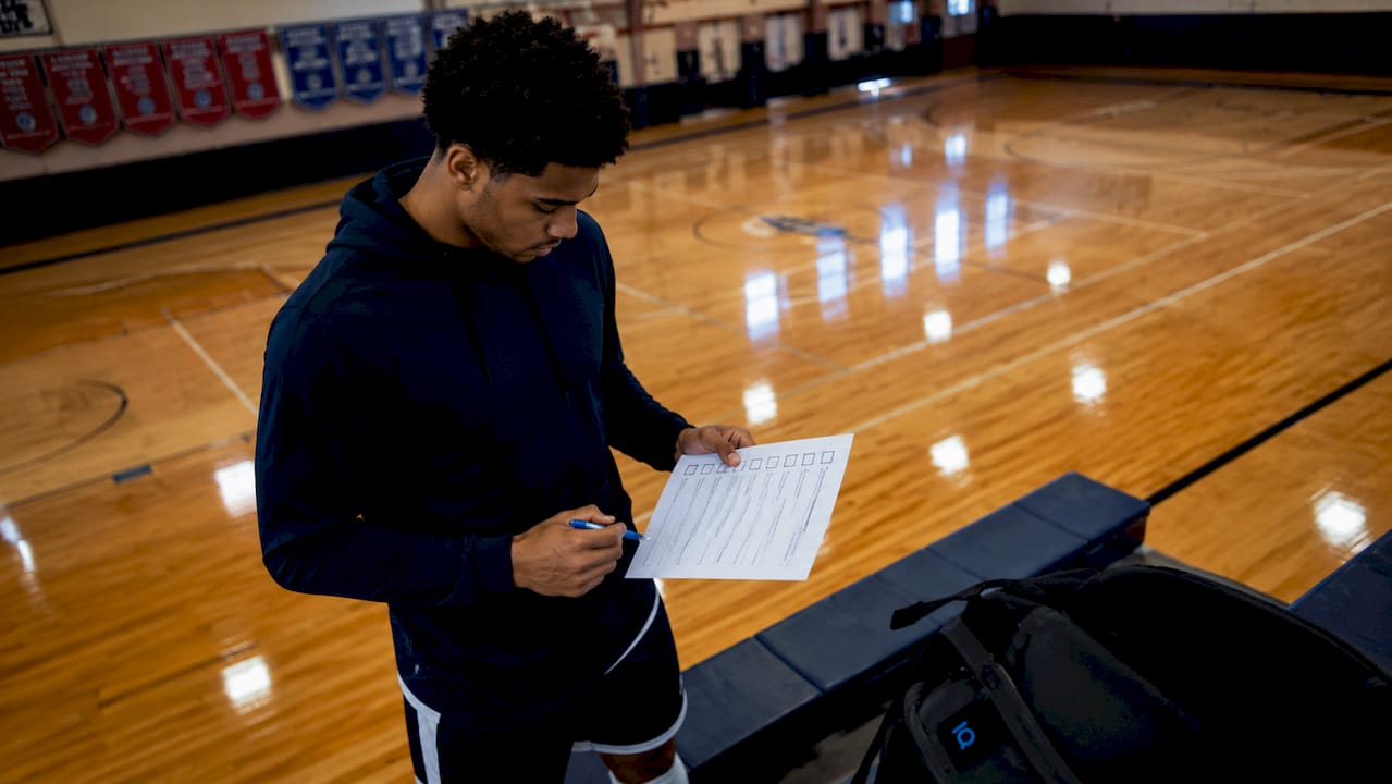 Athlete marking transfer process checklist in locker room