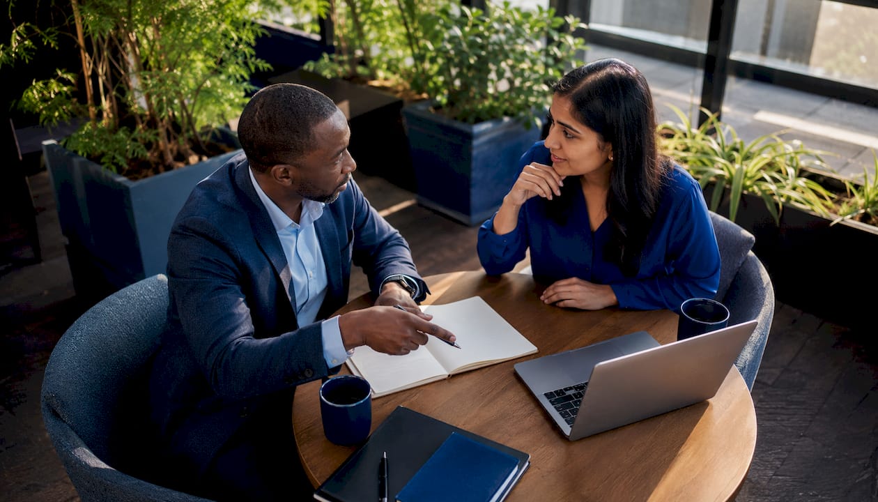 Two professionals collaborating on AI regulatory writing