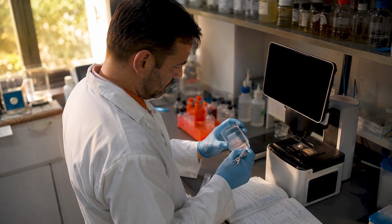 Profissional de laboratório a realizar análises a amostras biológicas