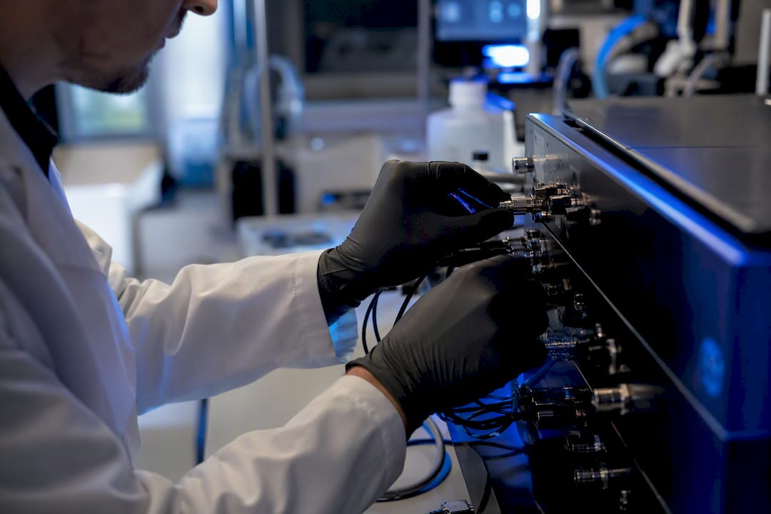 Hands adjusting biotech AI search hardware controls