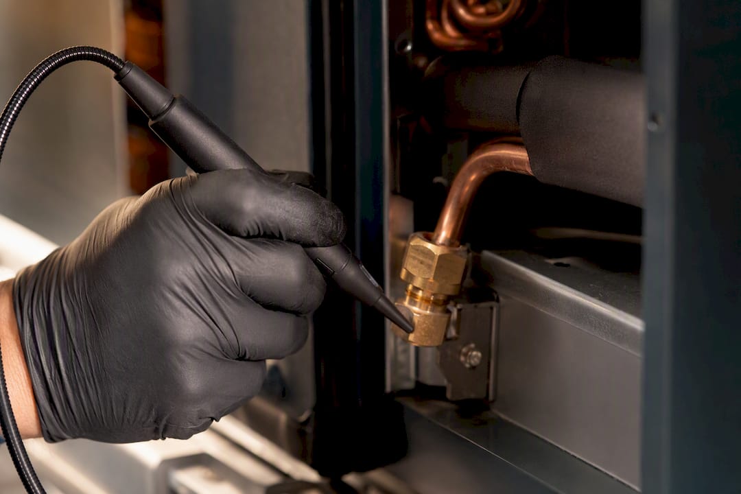 Technician tracing a refrigerant fitting