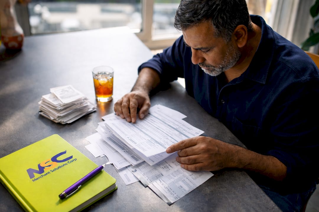 Person reviewing payment fee statements at desk