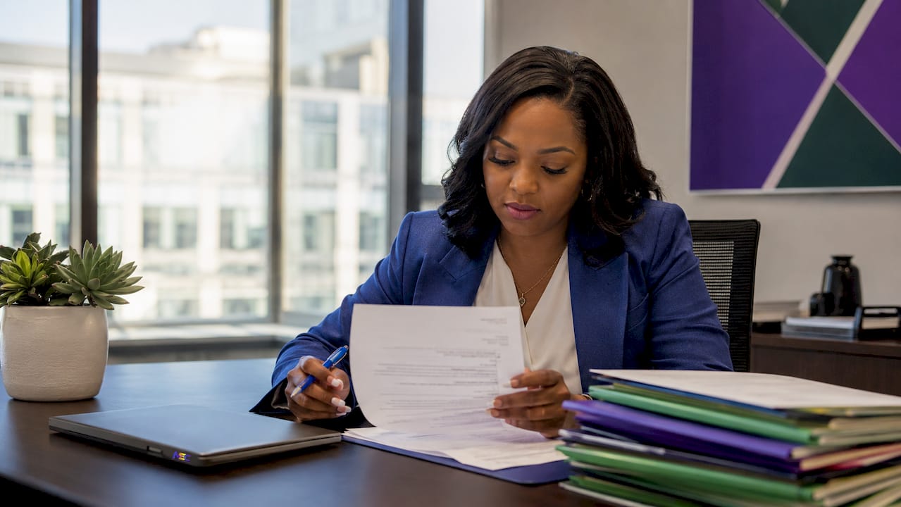 Lawyer reviewing ACH authorization forms at desk