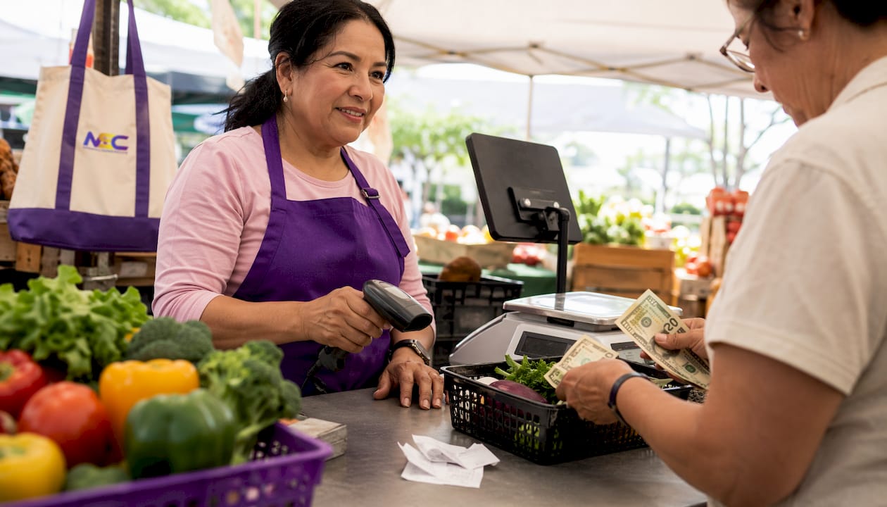Cashier processing cash payment at retail checkout