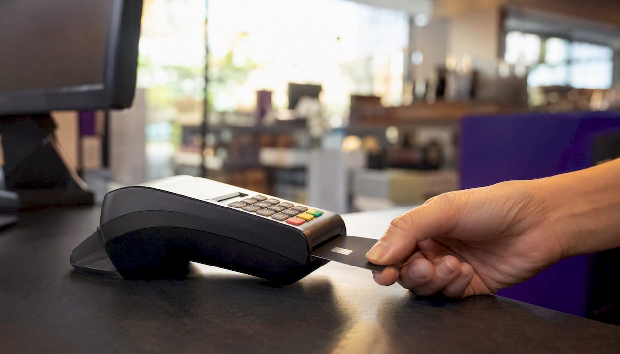 Hand inserting card into payment terminal