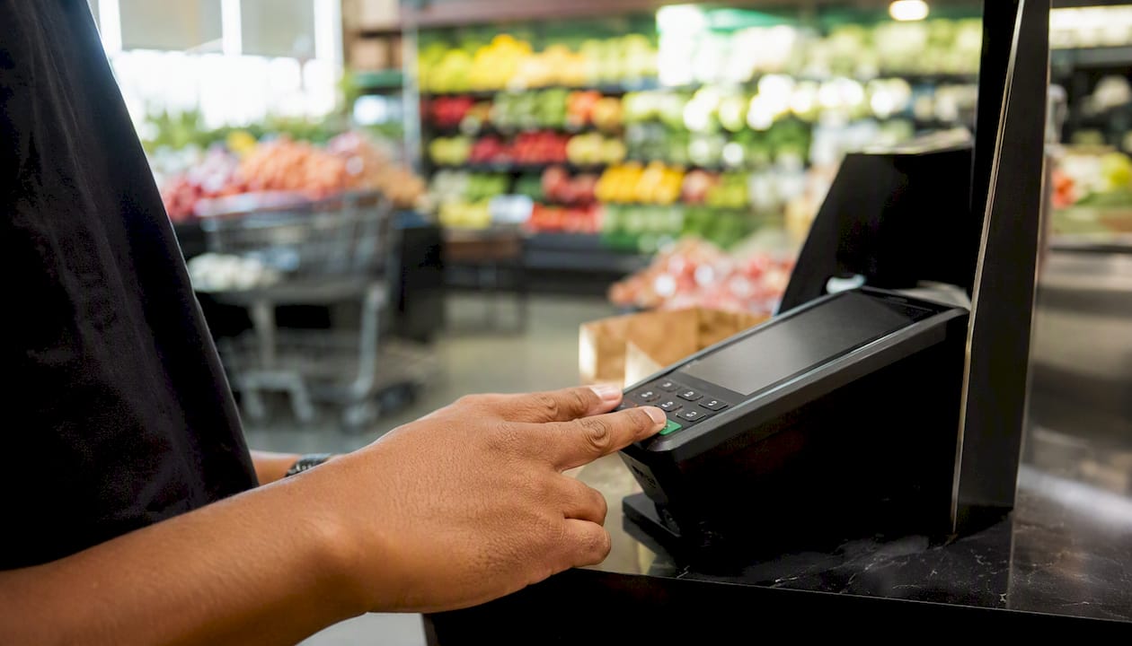 Hands closing batch on payment terminal