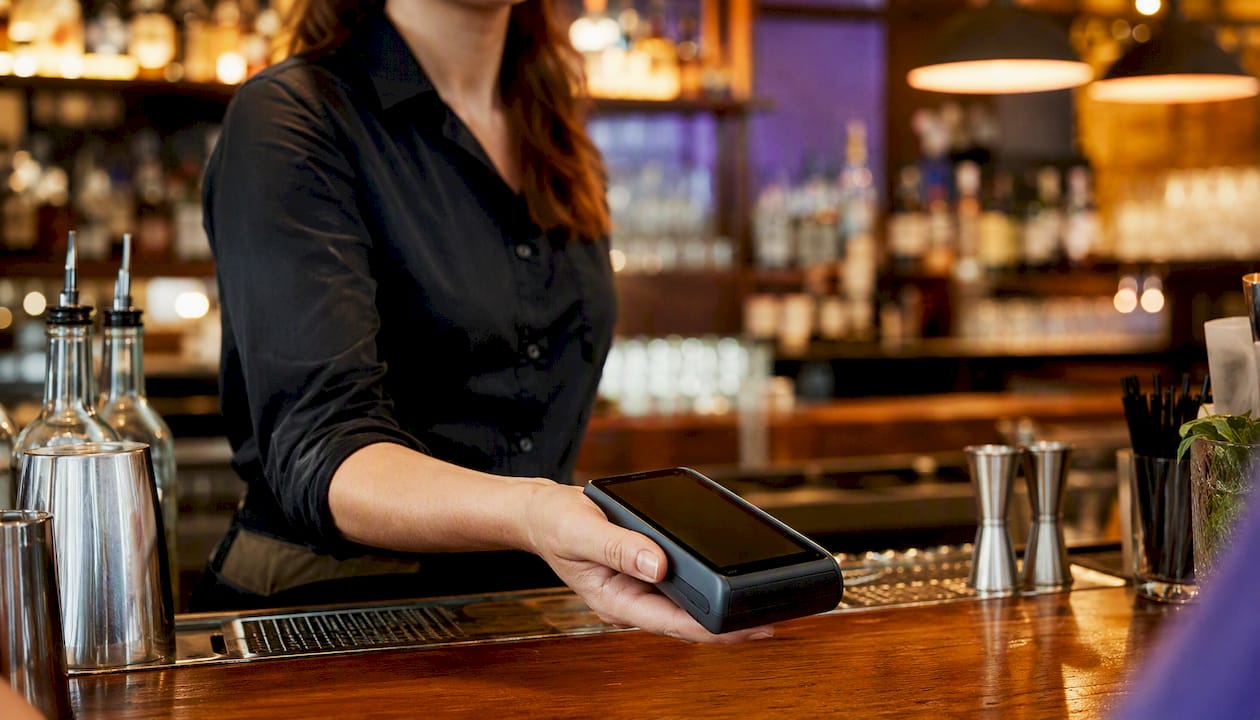 Restaurant server holding mobile payment device