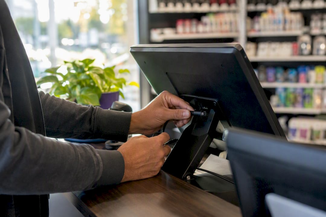 Hands setting up POS terminal hardware