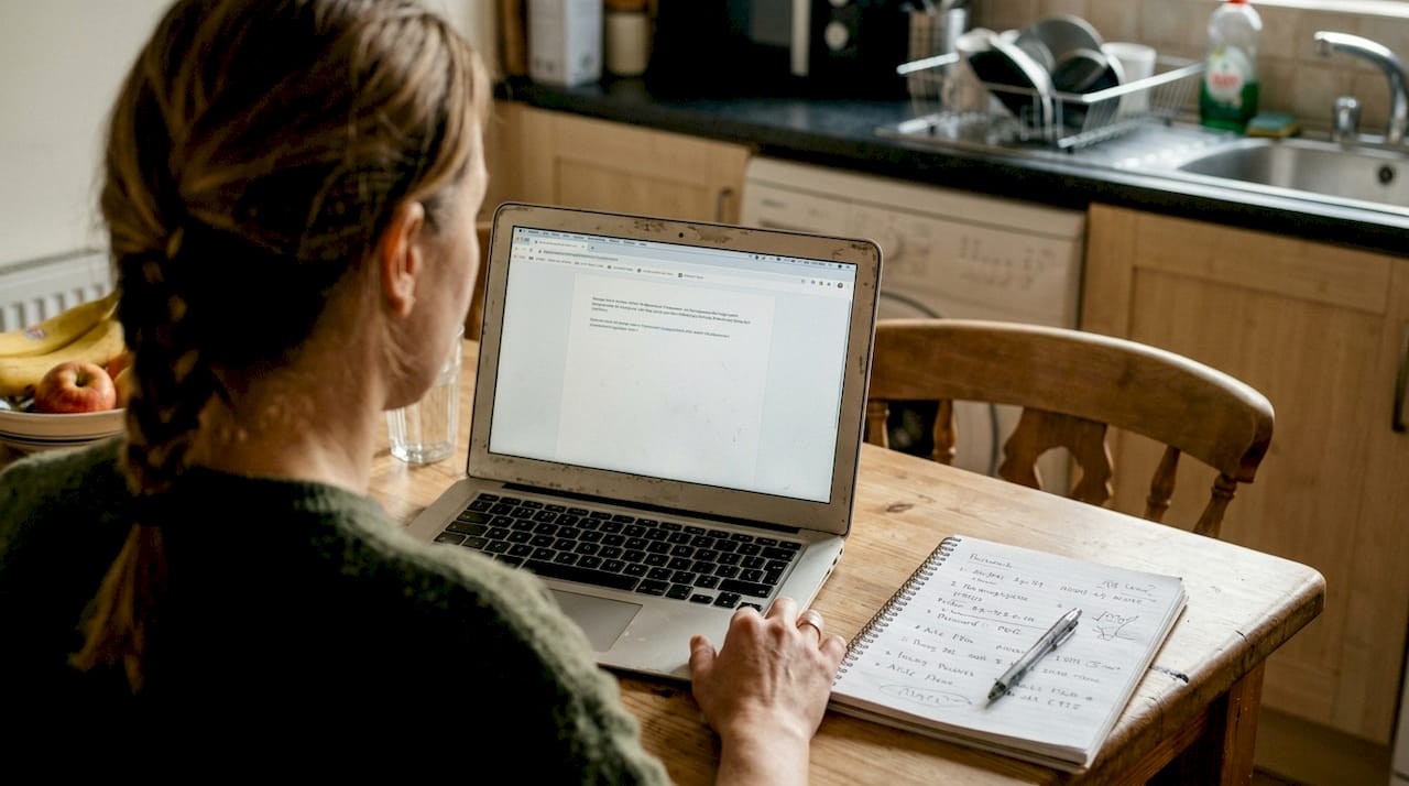 Woman referencing handwritten passwords in kitchen