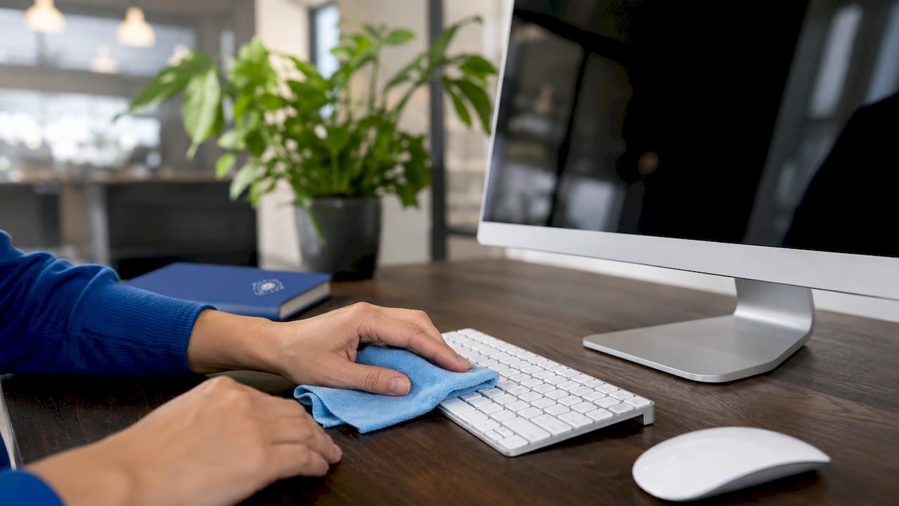 Hands cleaning keyboard with microfiber cloth