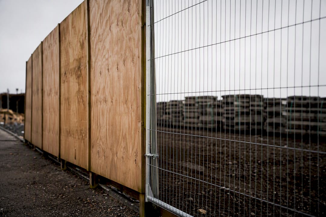 Timber plywood and mesh hoarding panels side by side