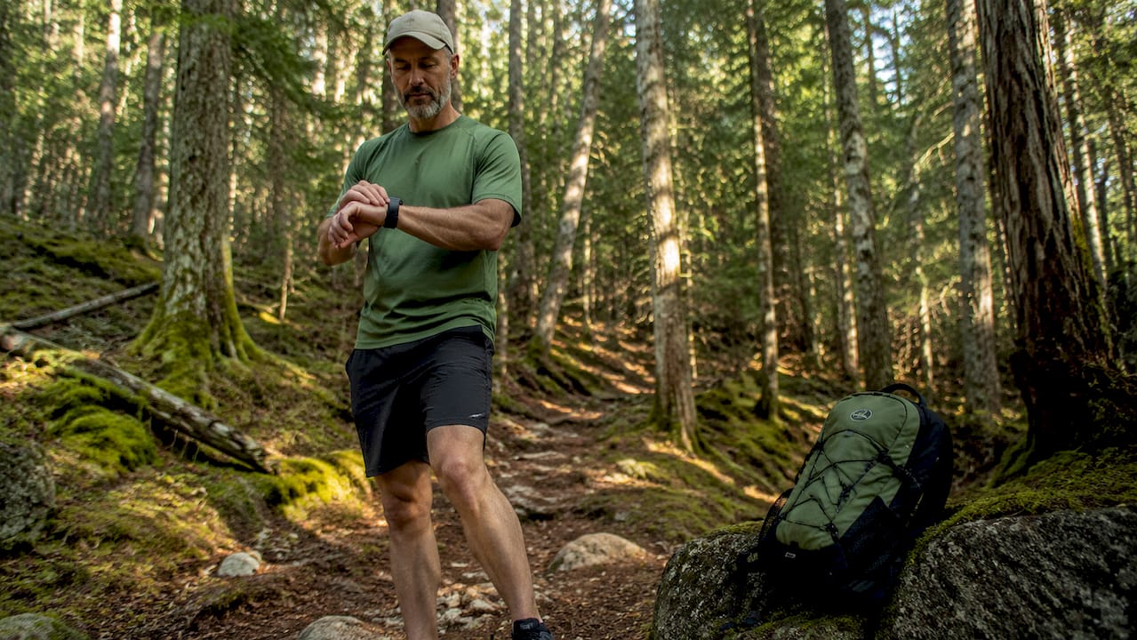 Man checking fitness tracker outdoors during walk