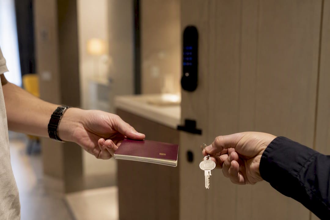 Mano che tiene un passaporto e la chiave di un appartamento