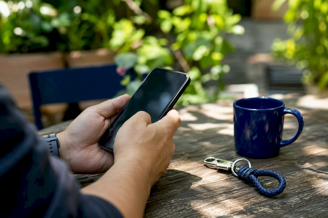 Hands holding phone at kitchen table