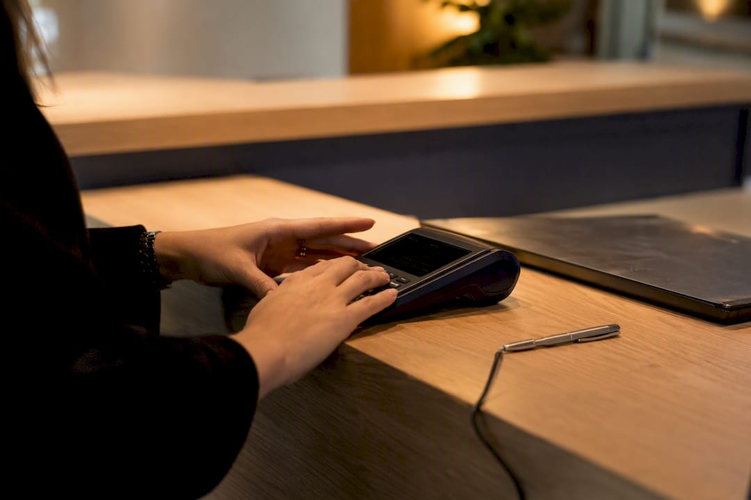 Mãos a usar tablet no balcão da receção