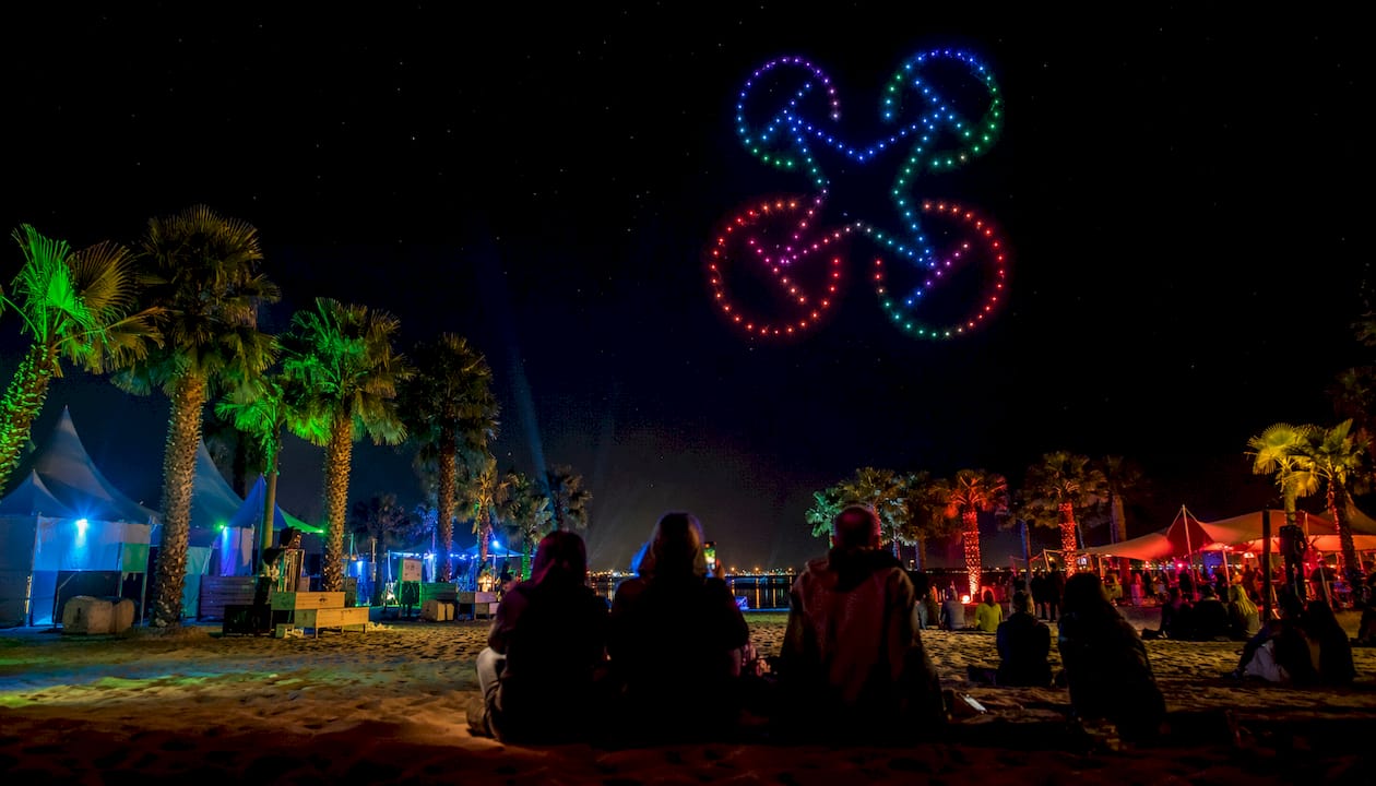 Un spectacle lumineux de drones éclaire la foule du festival avec une explosion de couleurs.