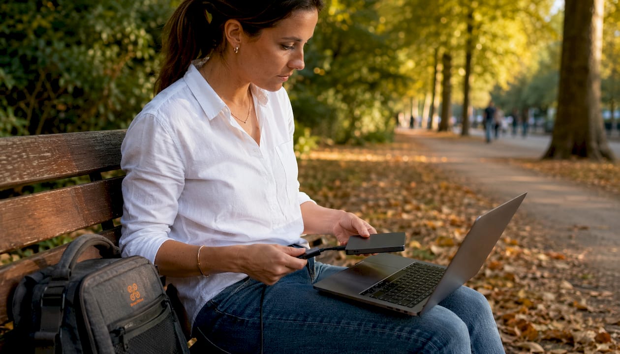 Une personne branche un disque SSD externe sur son ordinateur portable.