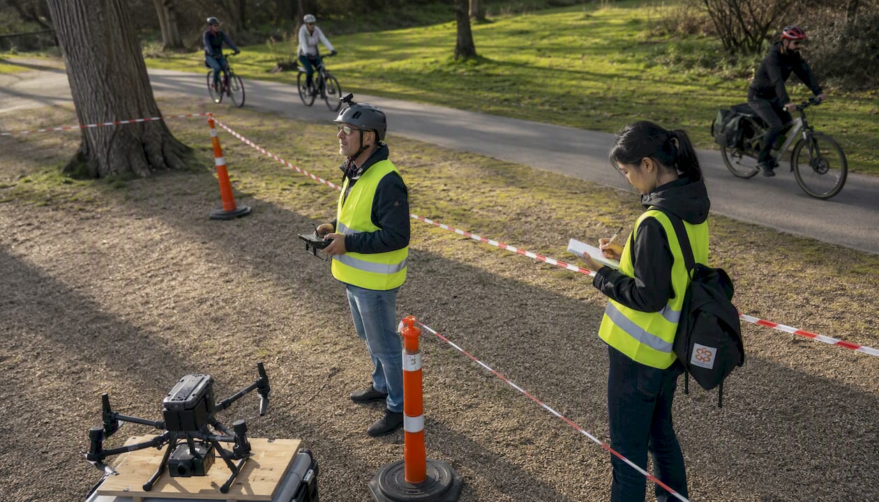 Un technicien installe des barrières pour sécuriser la zone de vol des drones.