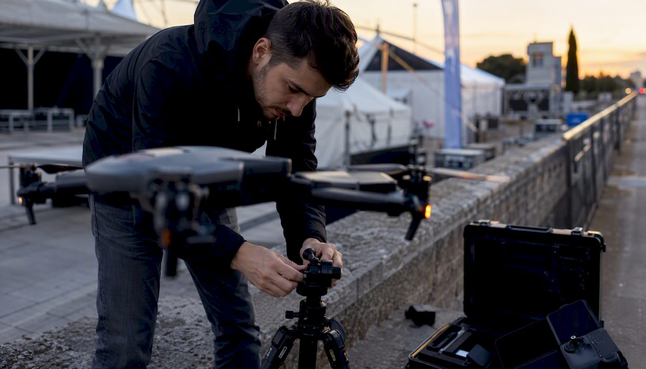 Des mains règlent la caméra d’un drone sur le lieu de l’événement.