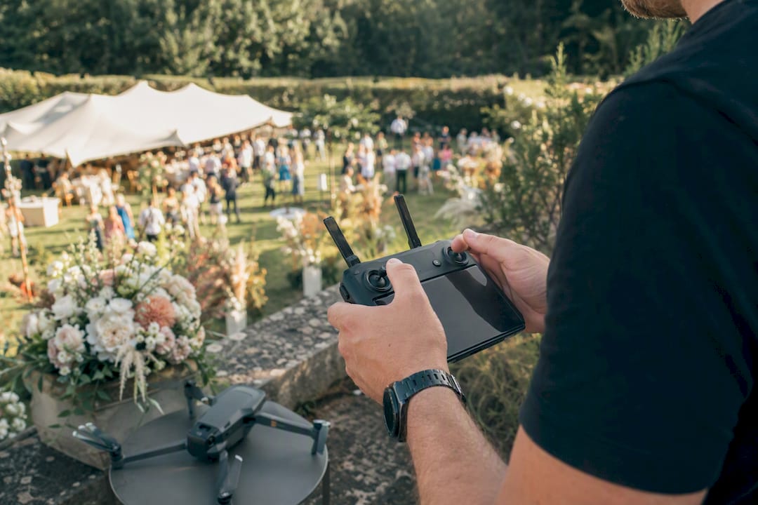 Un vidéaste pilote un drone pour capturer des images du mariage sur le lieu de la cérémonie.