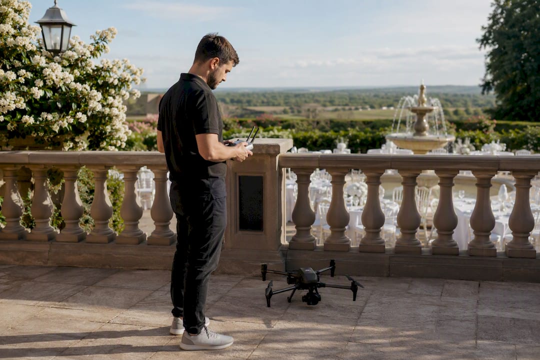 Un pilote de drone s’affaire aux derniers réglages avant de filmer le mariage.