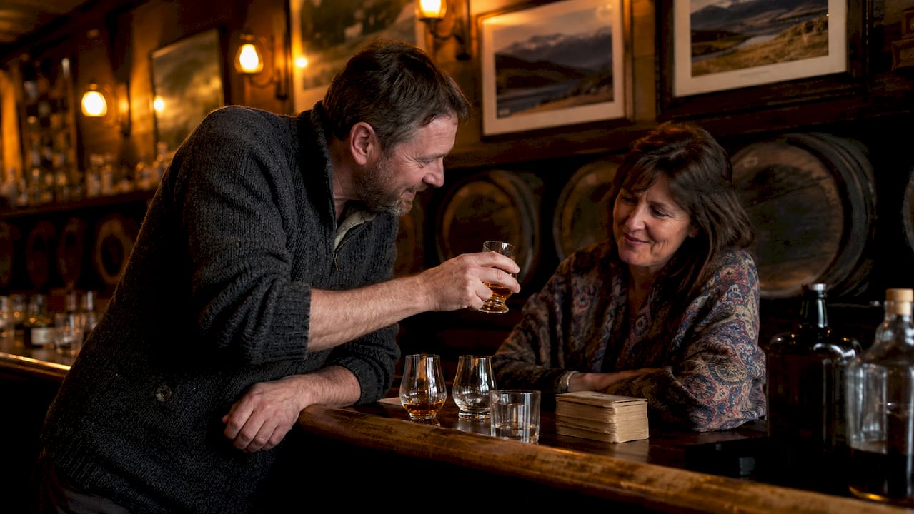 Man offering whisky dram in Scottish pub