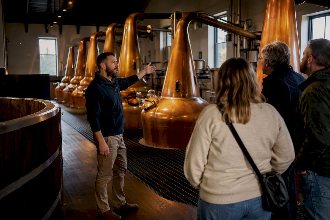 Visitors viewing copper stills during distillery tour