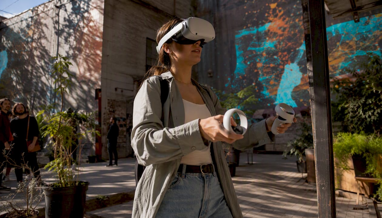Eine Besucherin taucht im Museum mit einer VR-Brille in digitale Kunstwelten ein.
