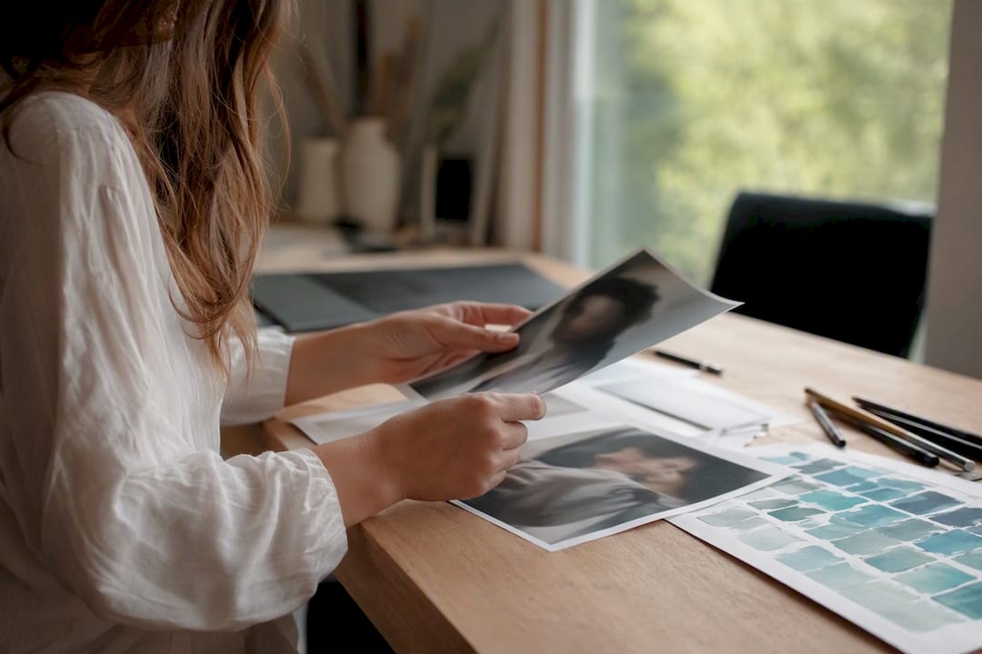 Hände wählen Fotos als Vorlage für die Karikatur aus