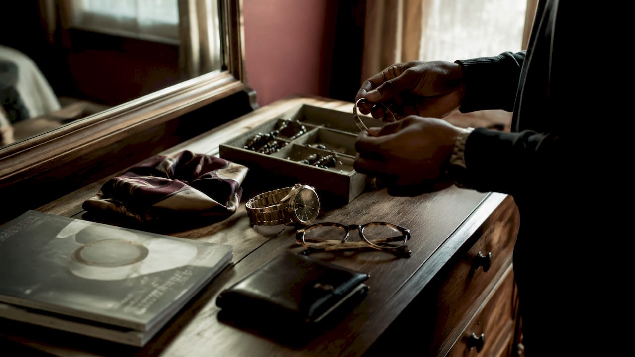 Hands selecting stylish personal accessories on table
