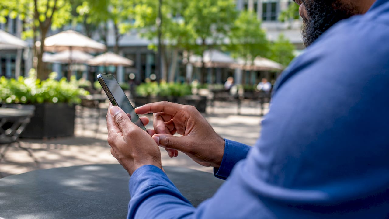 Hands scrolling LinkedIn profiles on smartphone