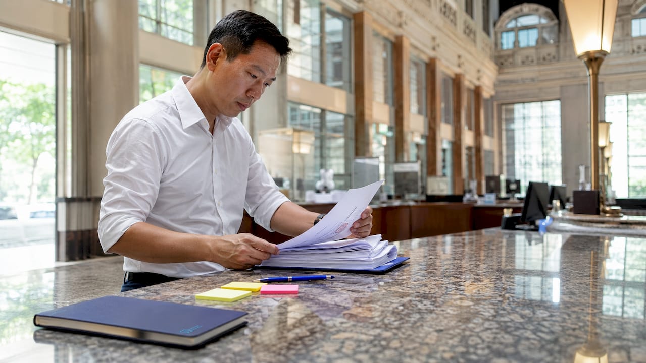 Businessperson reviewing registration documents in office