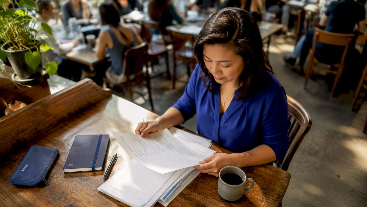 Business owner reviewing grant documents at desk