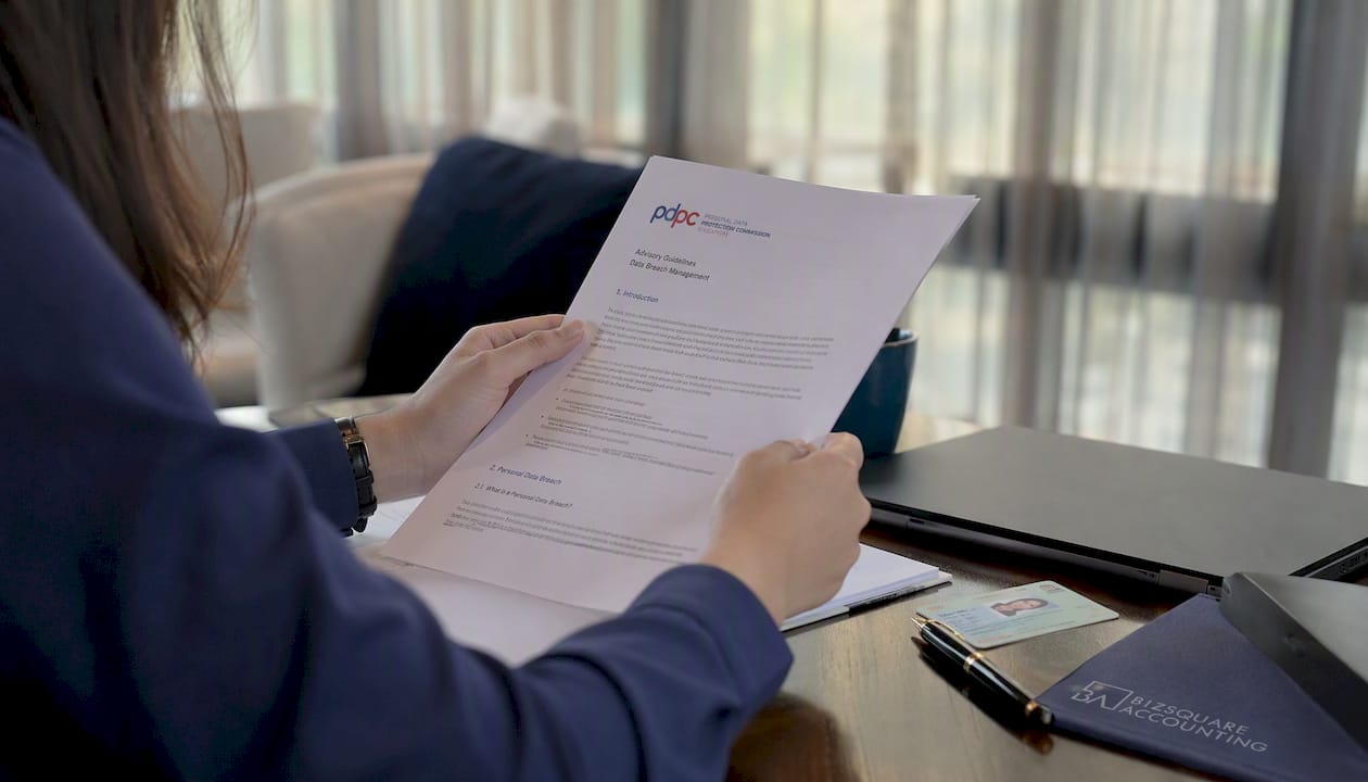 Hands reviewing Singapore business compliance papers