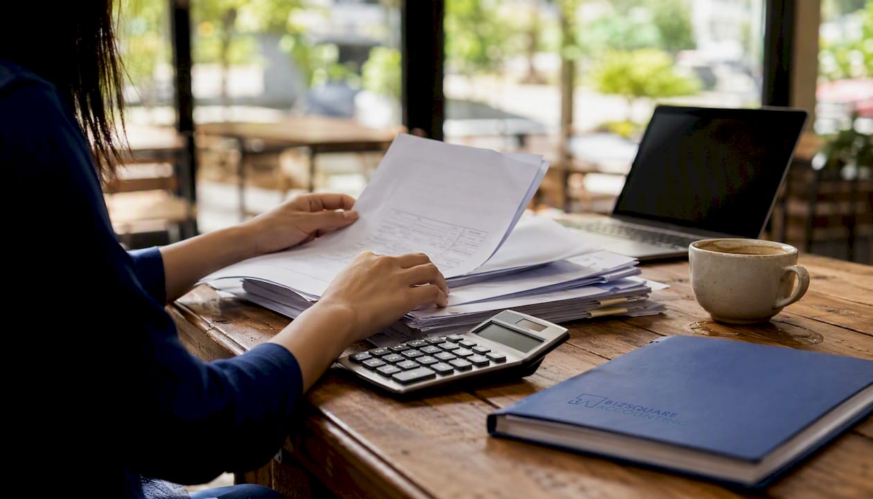 Hands adjusting accounting document on desk