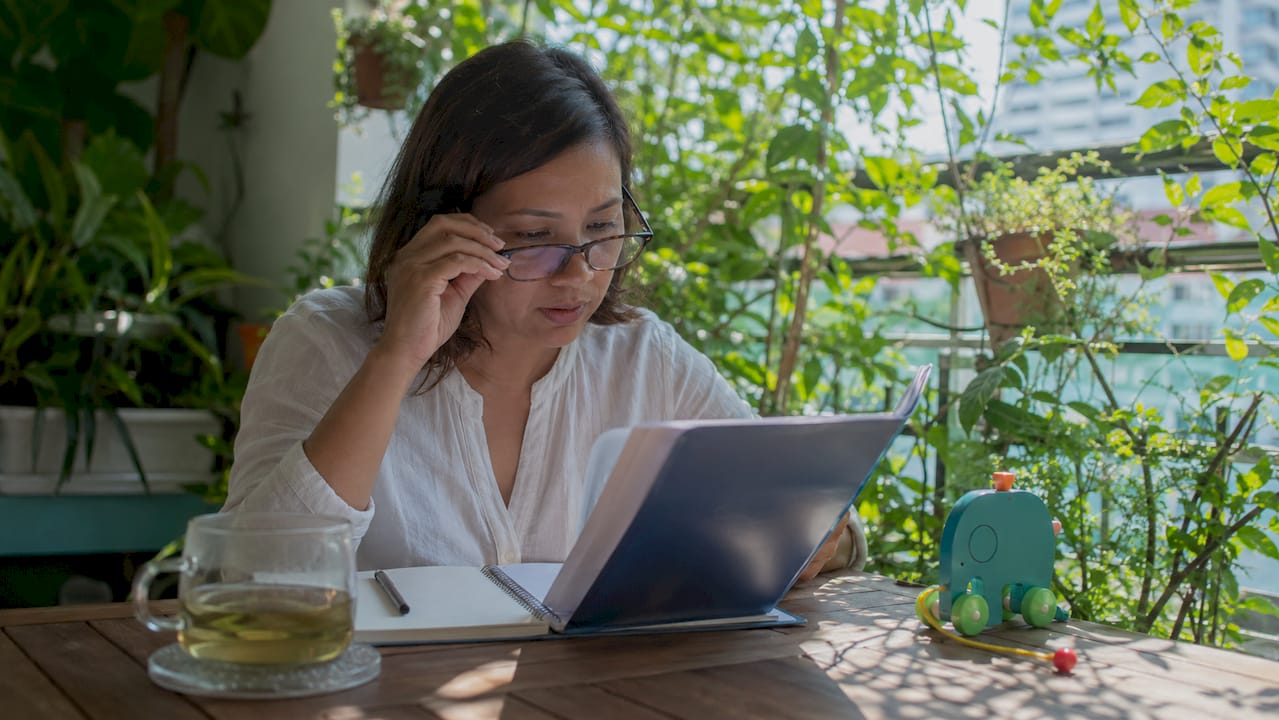 Mother reviewing curriculum guide at home