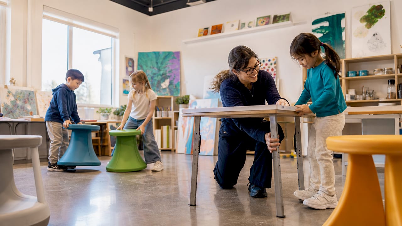 Teacher and children arranging flexible classroom furniture