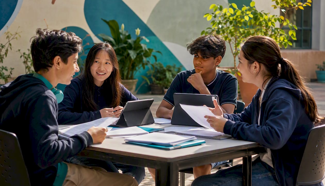 Group of students discussing work in classroom
