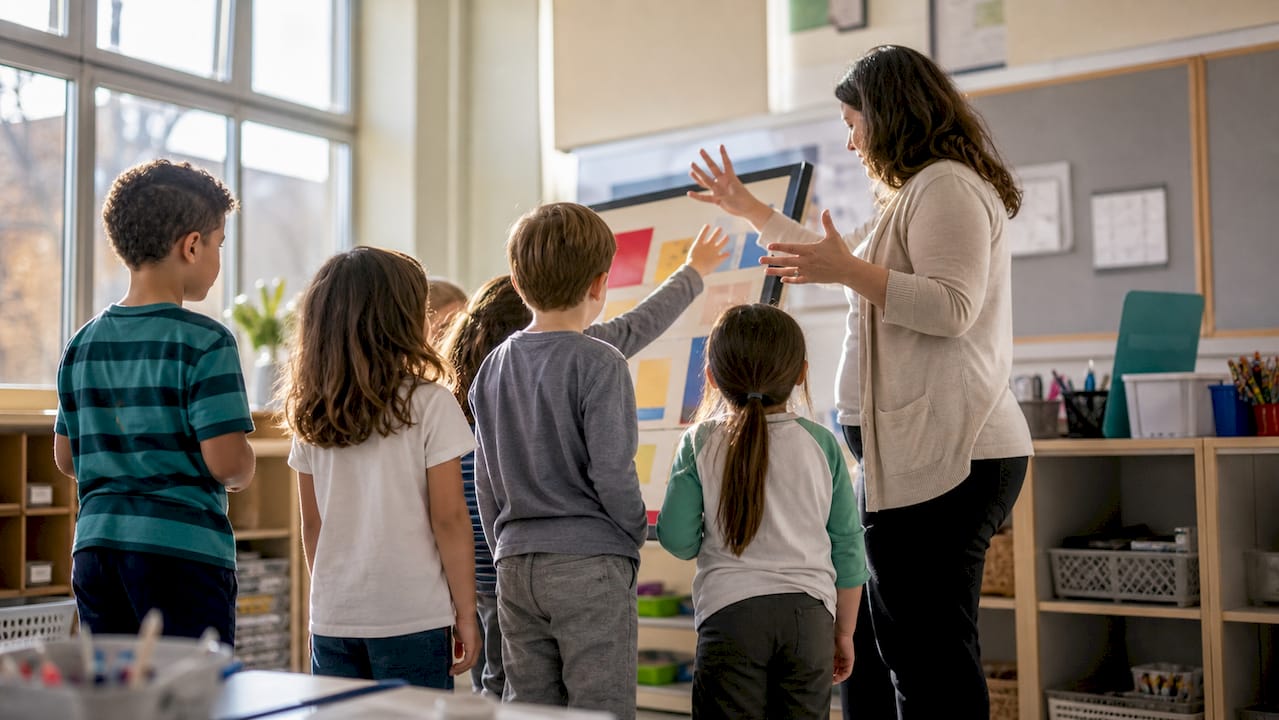 Teacher engaging children in classroom activity