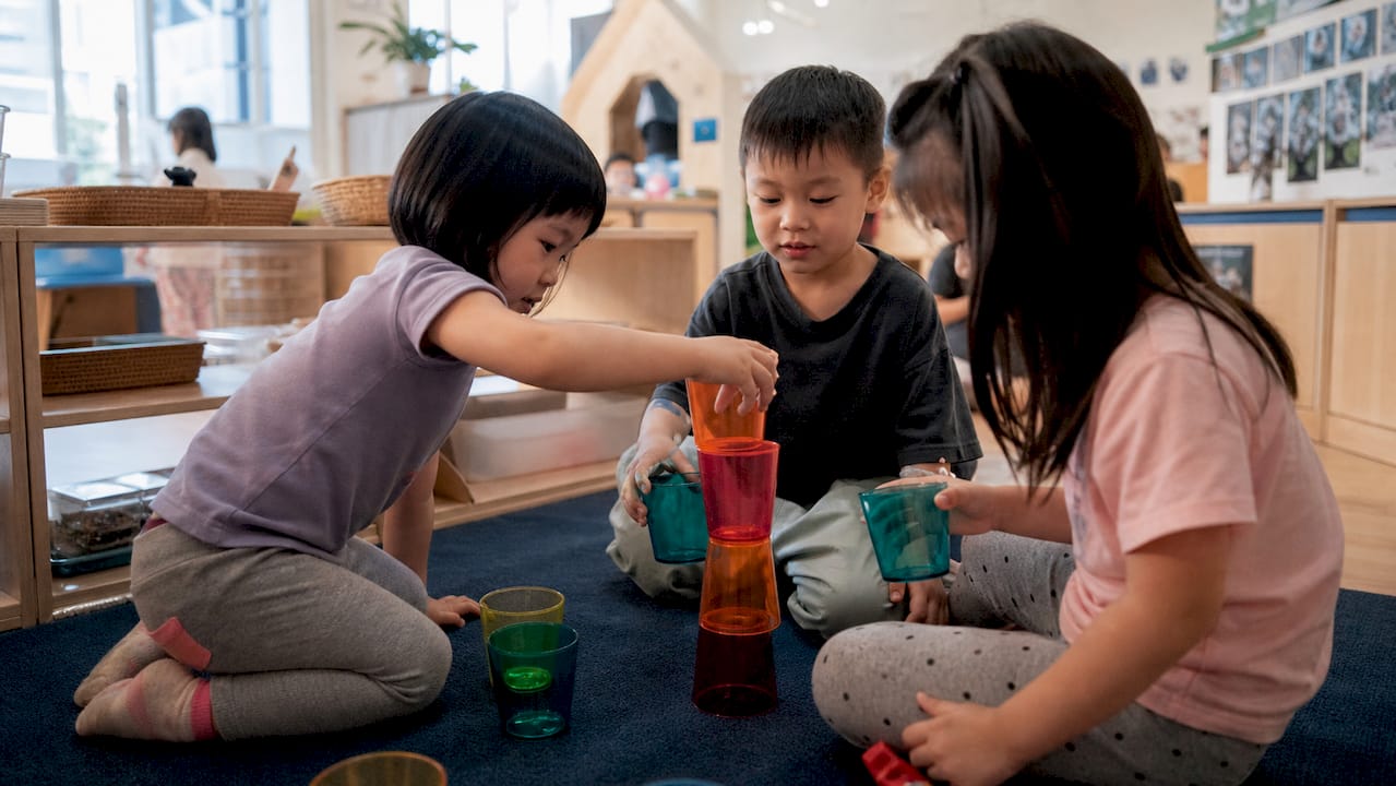 Children hands building blocks in classroom