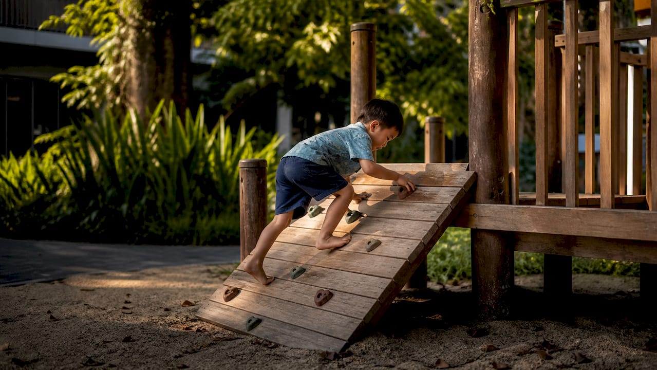 Child climbing on preschool playground structure
