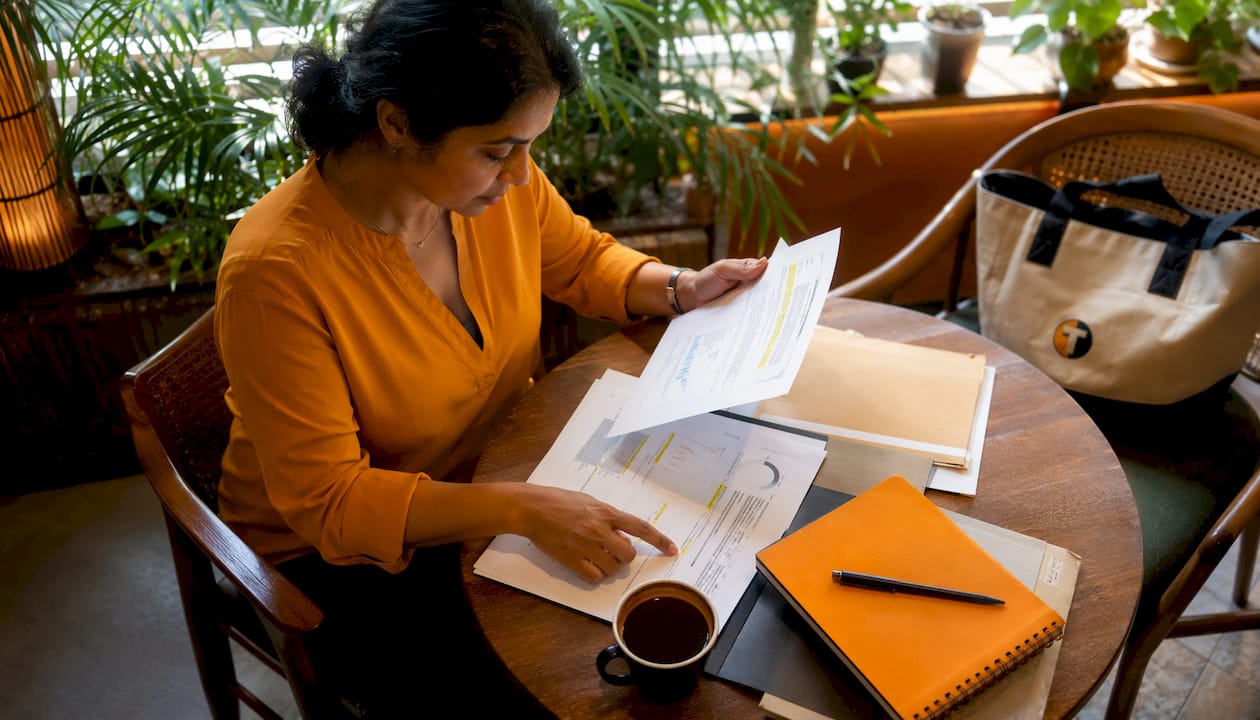Compliance officer reviewing trade reports at desk