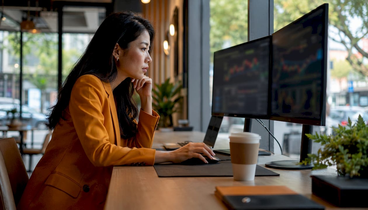 Trader analyzing multiple timeframe charts at desk