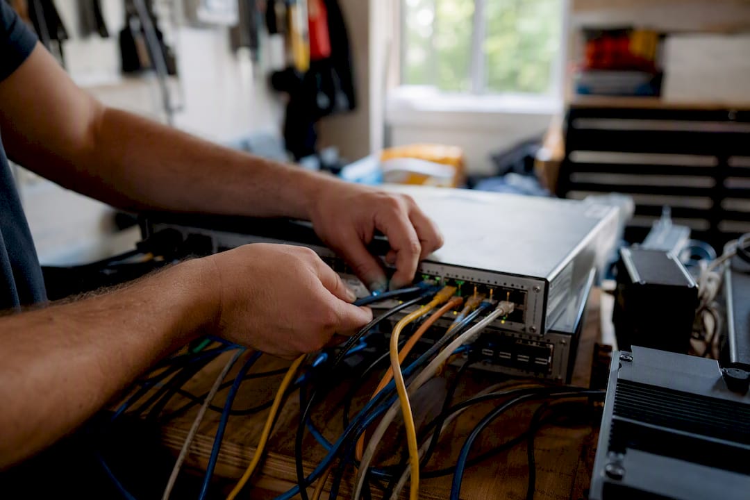 Hands connecting cables in crypto bot hardware setup